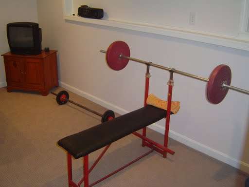 A workbench and free weights in a Basement Home Gym
