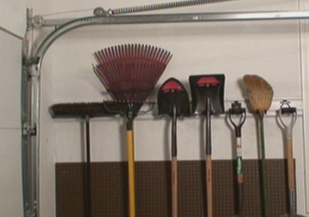 Pegboard used to protect drywall in the garage underneath the yard tools.