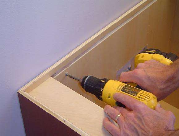 Bathroom Vanity Install - Installing screws to hold bathroom vanity to the wall.
